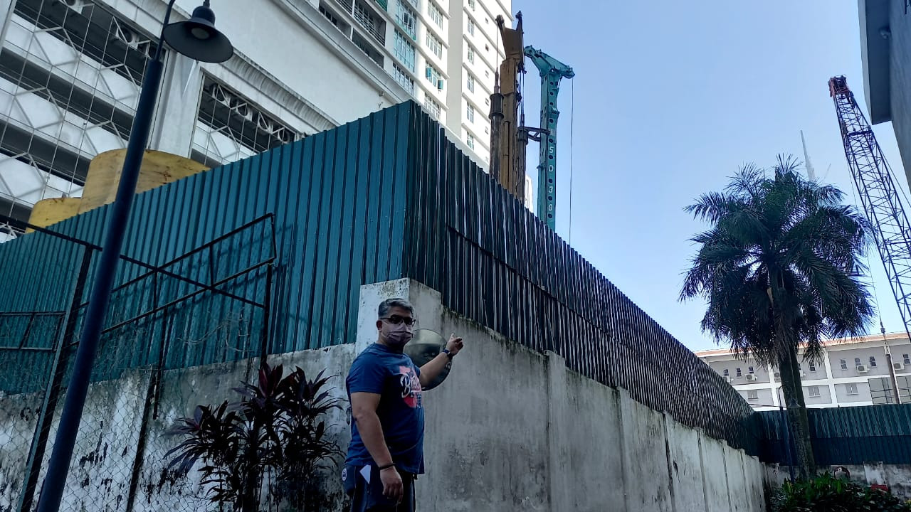 Dr Eratha Krishnan menunjukkan kren yang diletakan bersebelahan dengan perumahan Villa Scott dan Scott Sentral. - Gambar oleh Mastura Malak