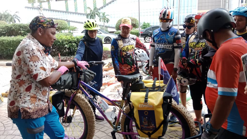 Khairil Aslan (kiri) berkongsi pengalaman bersama Pasukan Fatbike Johor. - Gambar oleh Izlaily Nurul Ain Hussein