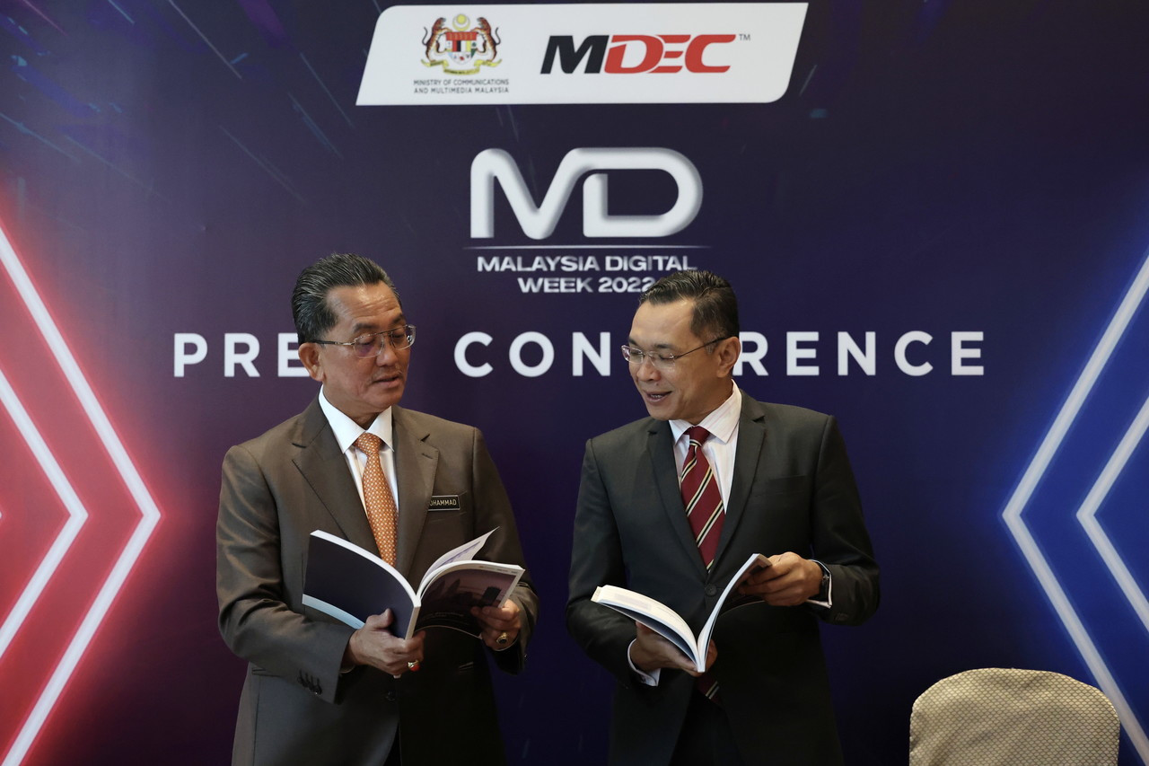 Ketua Setiausaha Kementerian Komunikasi dan Multimedia Datuk Seri Mohammad Mentek (kiri) bersama Mahadhir Aziz melihat kertas kajian bertajuk “Malaysia: Ke Arah Ibu Kota Digital ASEAN” selepas pelancaran Minggu Digital Malaysia 2022 MDEC di Pusat Persidangan dan Acara Connexion, baru-baru ini. - Gambar Bernama