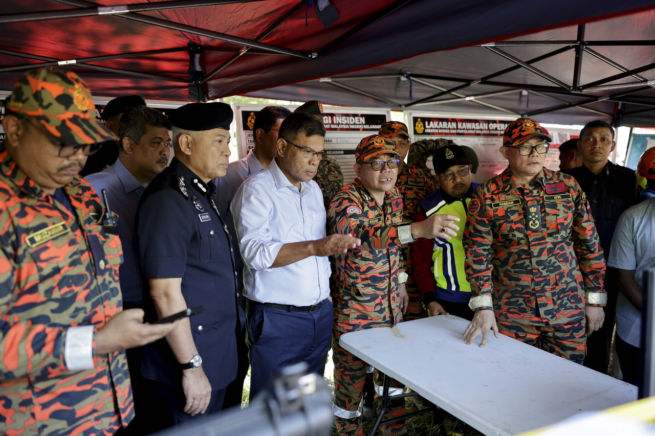  Menteri Dalam Negeri Datuk Seri Saifuddin Nasution Ismail (tiga, kiri) diberi penerangan oleh Pengarah Jabatan Bomba dan Penyelamat Malaysia (JBPM) Selangor, Datuk Norazam Khamis (empat, kiri) mengenai kejadian tanah runtuh berhampiran tapak perkhemahan di Father's Organic Farm, Batang Kali hari ini. - Gambar Bernama