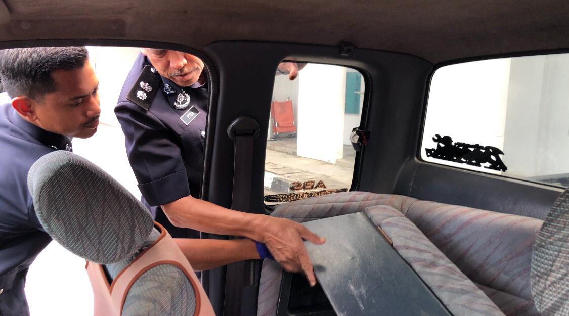 Rodzi Abu Hassan (kanan) menunjukkan ruang kosong di bawah kerusi penumpang belakang yang menjadi tempat menyorokkan ganja - gambar Rafisqi Radhi