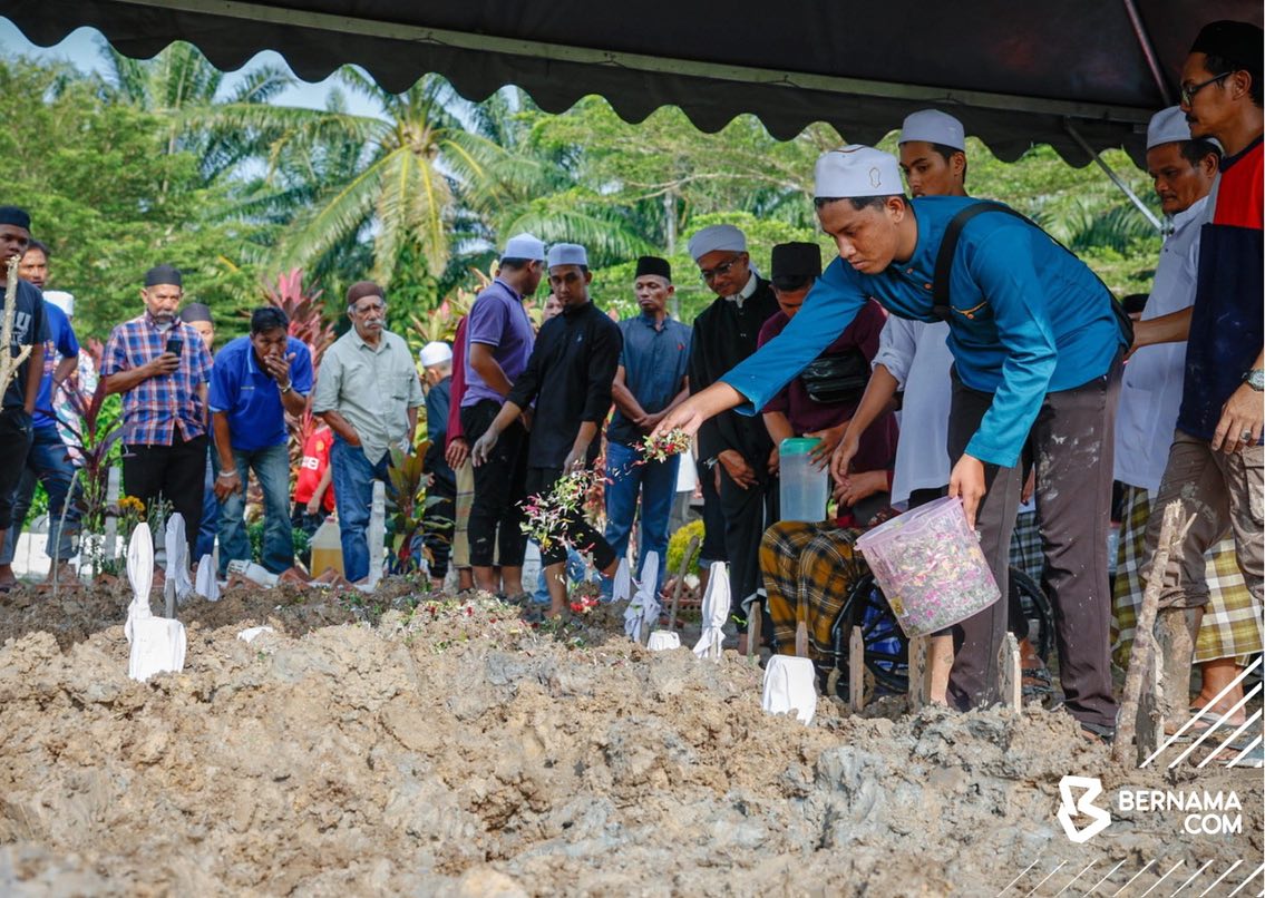 Abdurrahman menyiram air ke pusara ahli keluarganya. - gambar BERNAMA