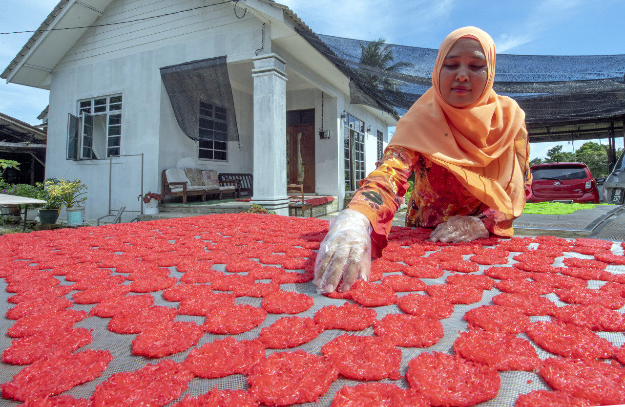 Mastura membalikkan kerepek Ginang setiap empat jam bagi memastikan ia benar-benar kering. - Gambar Bernama