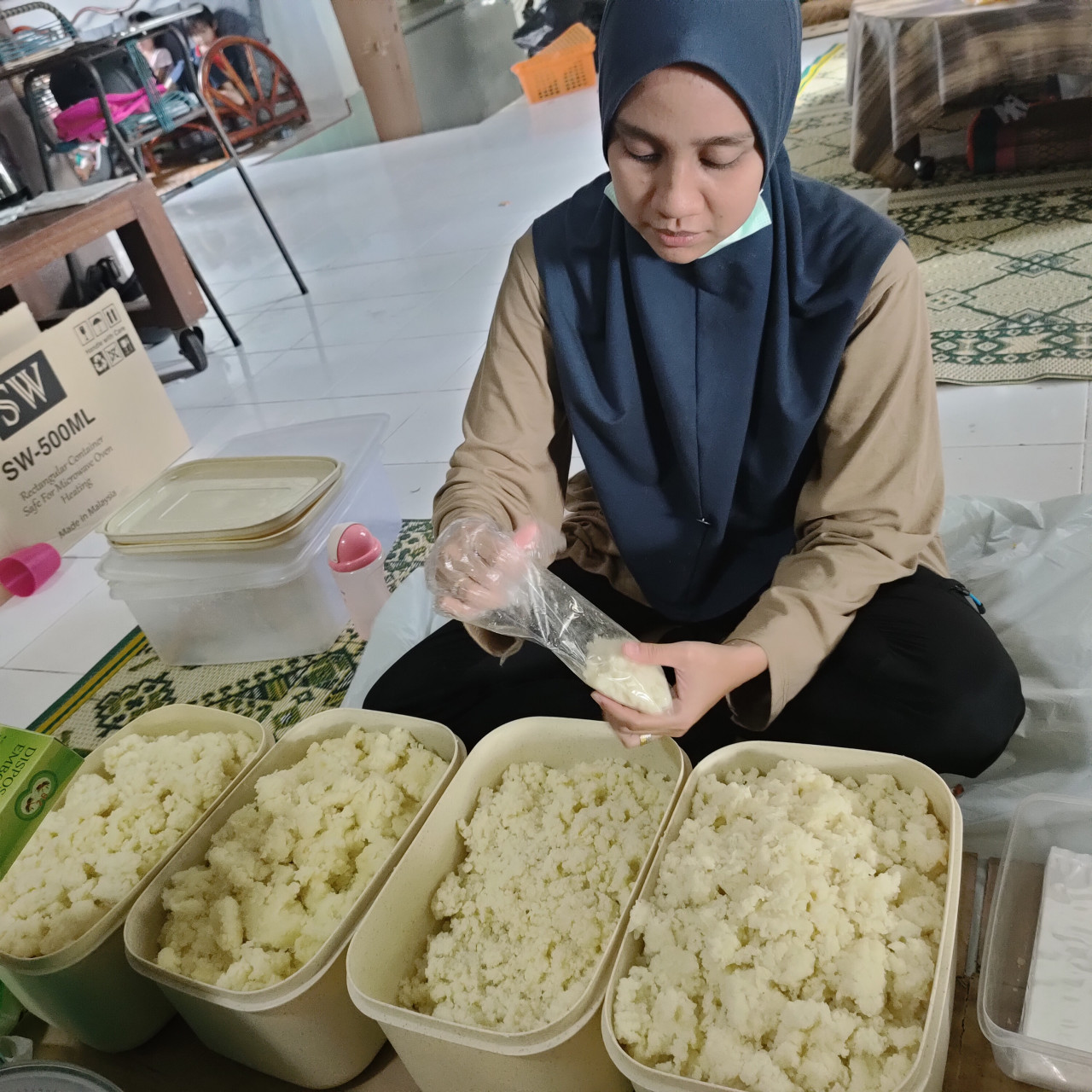 Hanisah membungkus kuih Tahi Itik di rumahnya di Kampung Tikat, Kota Bharu.