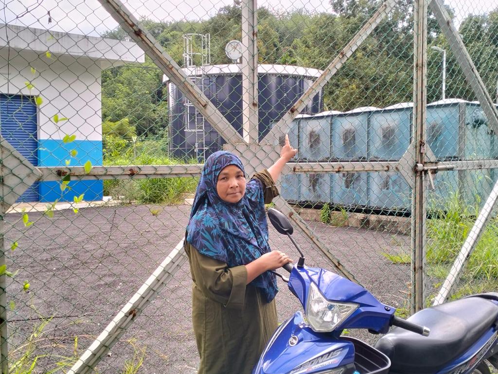 Penduduk Kampung Wang Perah, Nor Hayati Md. Zain menunjukkan tangki air milik SADA dalam kampung tersebut yang masih belum mampu menyelesaikan masalah bekalan air di situ.