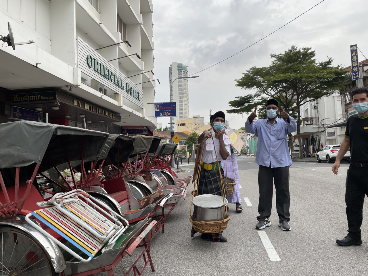 Ahamed Seeni (dua dari kanan) bersama pekerjanya mengedarkan paket nasi kandar kepada golongan yang memerlukan.