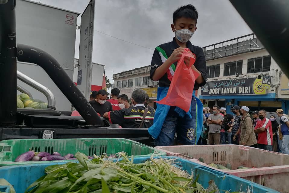 Long Choeng You, 11, tidak melepaskan peluang untuk menjadi sukarelawan dalam misi bantuan banjir fasa pertama anjuran PEKATA di Taman Inderapura, di sini, hari ini.