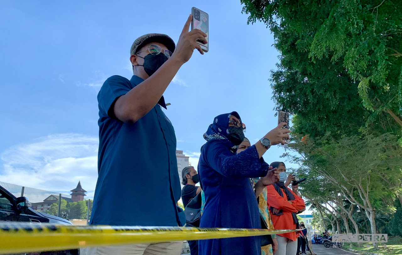 Beberapa penyokong merakamkan gambar dari jauh ketika calon mereka memasuki PPC.