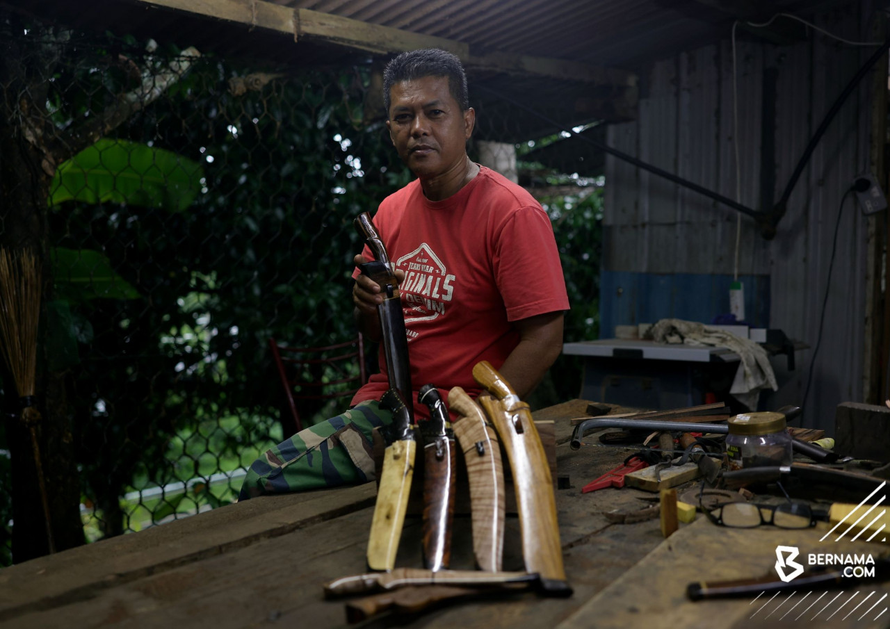 Anizam Mohd Deris menunjukkan parang yang dihasilkan. - gambar BERNAMA