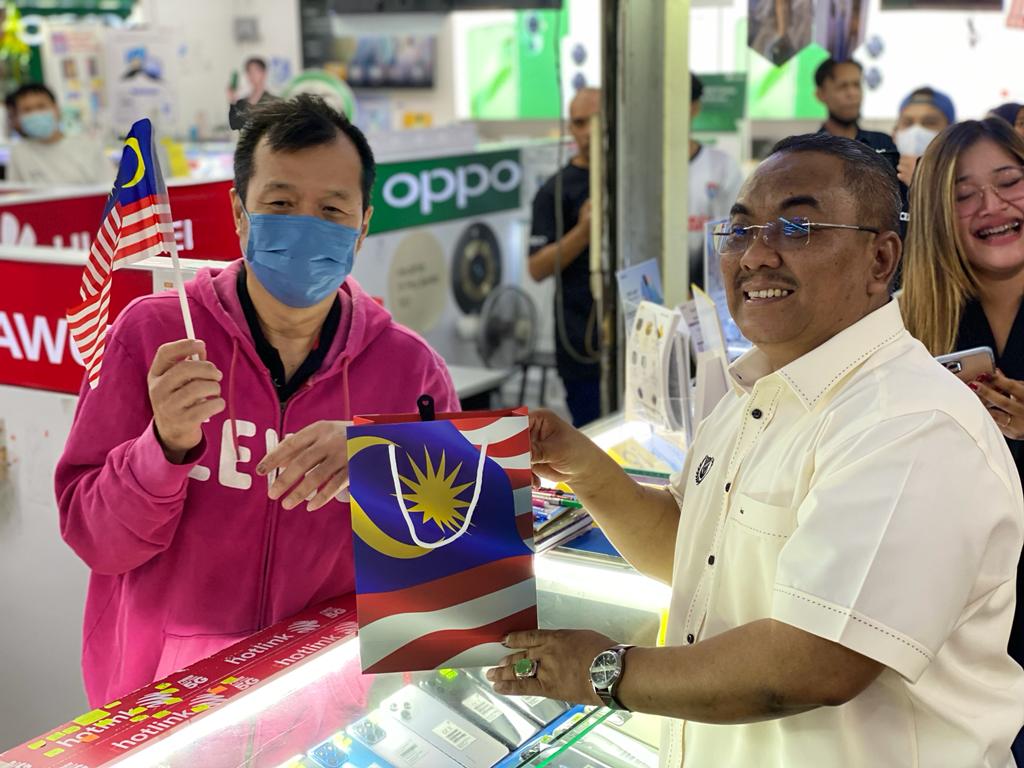 Muhammad Sanusi (kanan) beramah mesra dengan peniaga selepas melancarkan Kempen Kibar Jalur Gemilang Peringkat Negeri Kedah - gambar Rafisqi Radhi