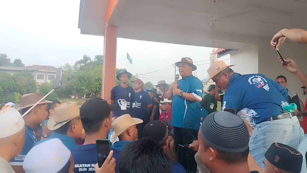 Muhammad Sanusi (tengah) berucap sebelum perlawanan bola sepak persahabatan di Padang Awam, Felda Teloi Timur - gambar Rafisqi Radhi