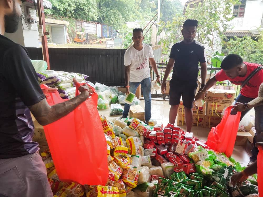 Sukarelawan membantu menyusun barang keperluan untuk diagihkan.