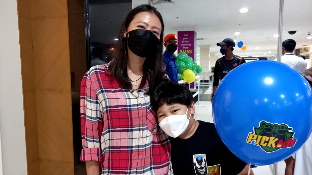 Sheryl Cornelius bersama anaknya berusia tujuh tahun melahirkan rasa teruja untuk mengambil suntikan vaksin untuk Program PICKids di WTCKL hari ini. - Gambar oleh Masutra Malak