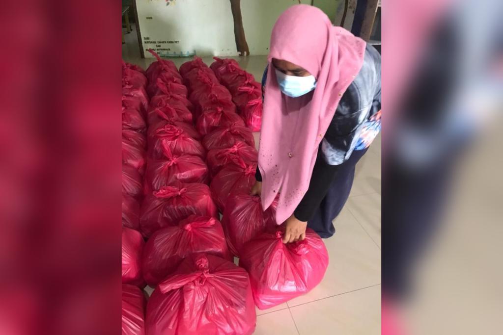 Sukarelawan NASOM sedang menyusun pek barangan keperluan asas melalui inisiatif Give Back Friday untuk diagihkan kepada keluarga terjejas akibat COVID-19.