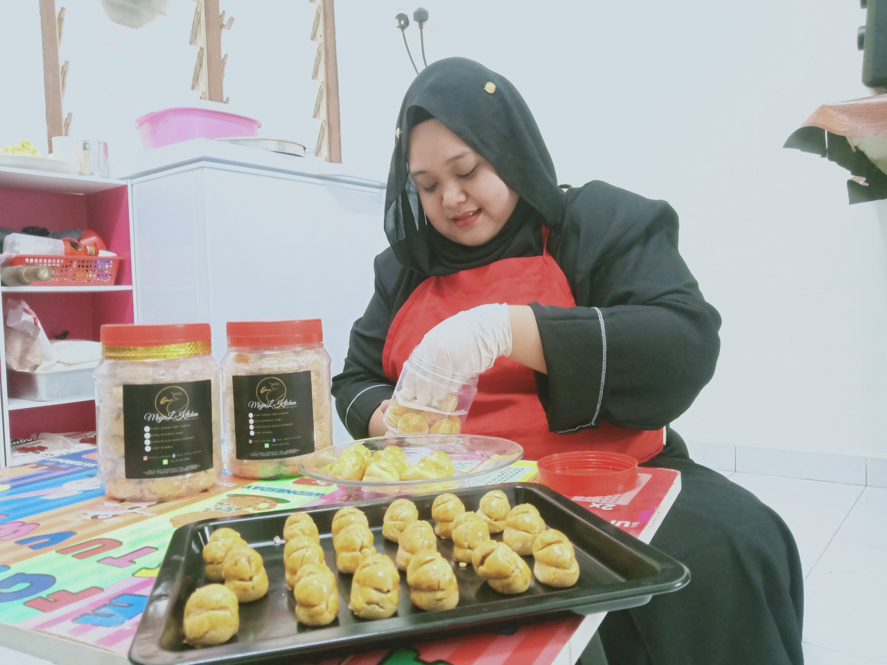 Ammelia Izati memasukkan tart yang sudah siap dimasak ke dalam bekas.