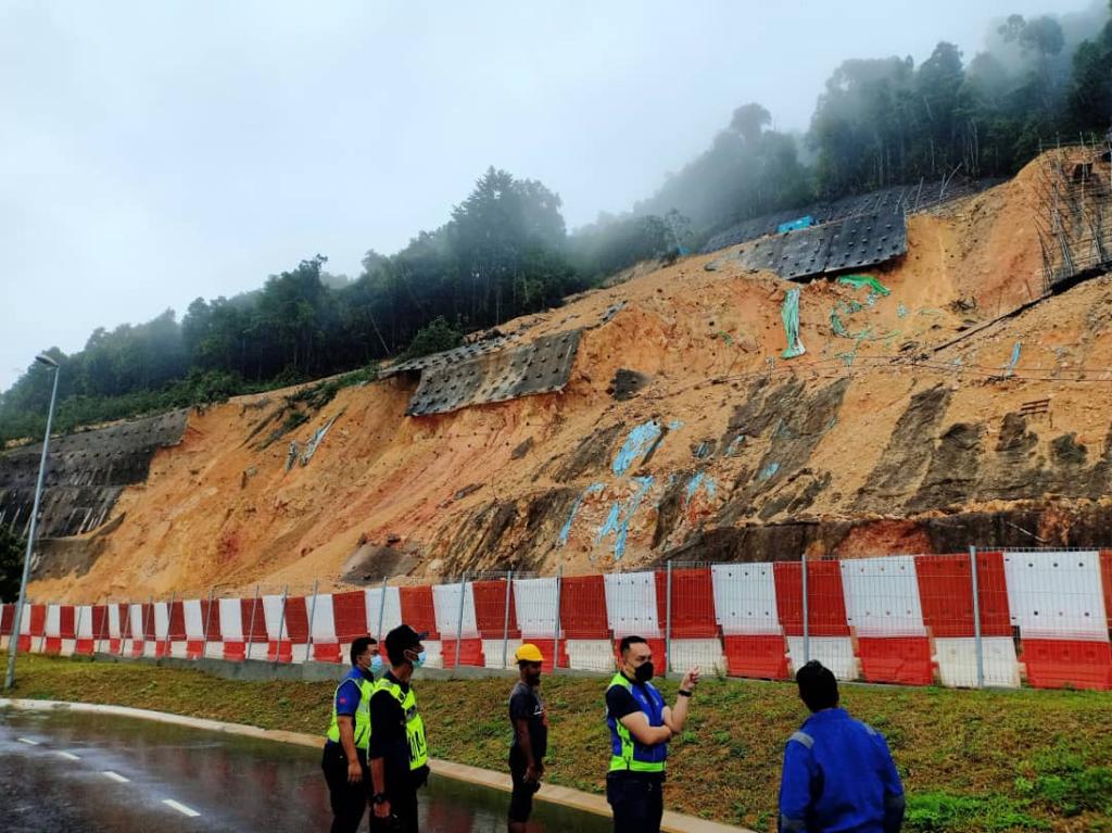 Pihak polis memantau keadaan tebing tanah runtuh dan banjir yang berlaku di kawasan Kota Tinggi. - Gambar ihsan Polis