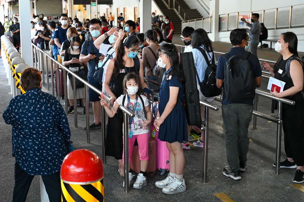 Orang ramai menunggu bas yang menghala ke Johor dari Singapura di bawah program VTL pada 29 November. - Gambar AFP