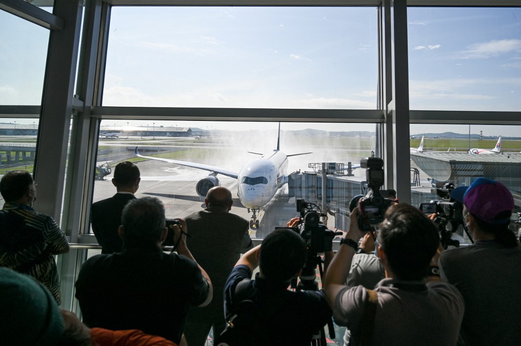 Sebuah pesawat Singapore Airlines disiram air sejurus mendarat di KLIA di bawah program VTL di Sepang pada 29 November. - Gambar AFP