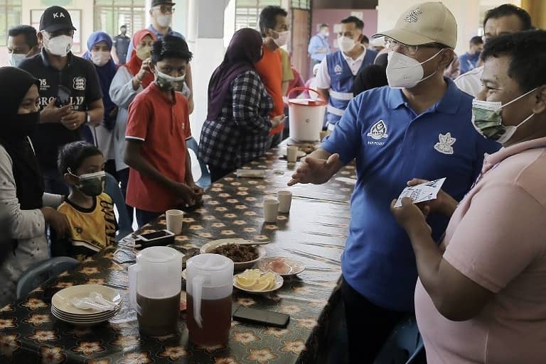 Wan Rosdy (dua dari kanan) bersama penduduk ditempatkan di PPS SMK Ubai, dekat sini.