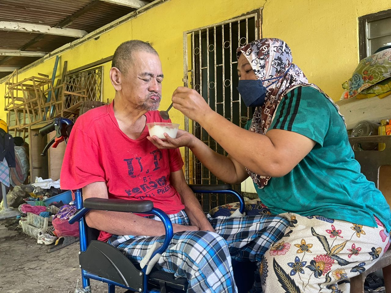 Asmanida Ismail menyuapkan bubur kepada suaminya, Abdul Rahman Tasu di kediaman mereka dekat Pekan Langgar.