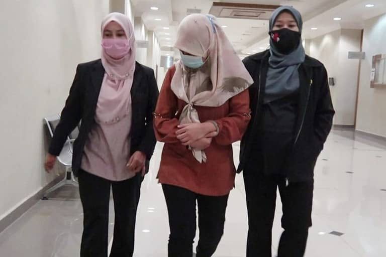 Zuraini (tengah) diiringi pegawai SPRM selepas proses pendakwaan di Mahkamah Sesyen Kuantan hari ini.