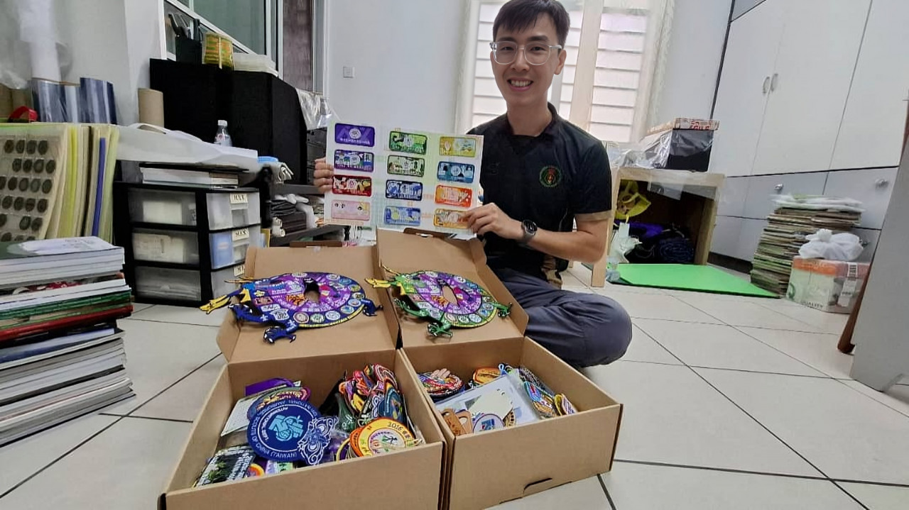 Anak lelaki Chan Foo Keong, Chan Zen, menunjukkan tampalan yang dikumpulnya semasa pertemuan kem antarabangsa baru-baru ini. – Gambar Jason Santos