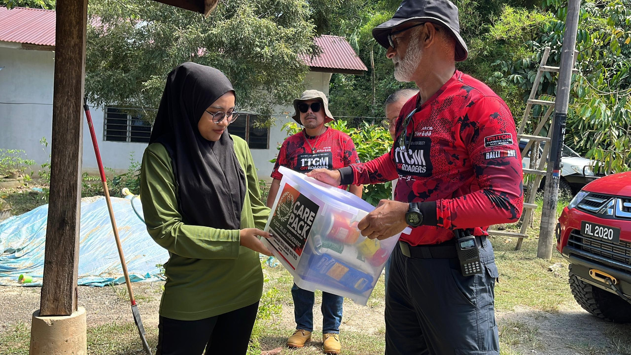 Nur Zawani Zailani (kiri) menerima bantuan yang disampaikan seorang ahli TTCM - Gambar Amirah Abu Bakar