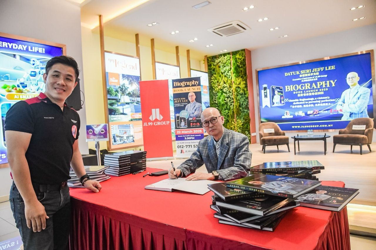 Jeff BK Lee menandatangani buku yang dibeli seorang tetamu