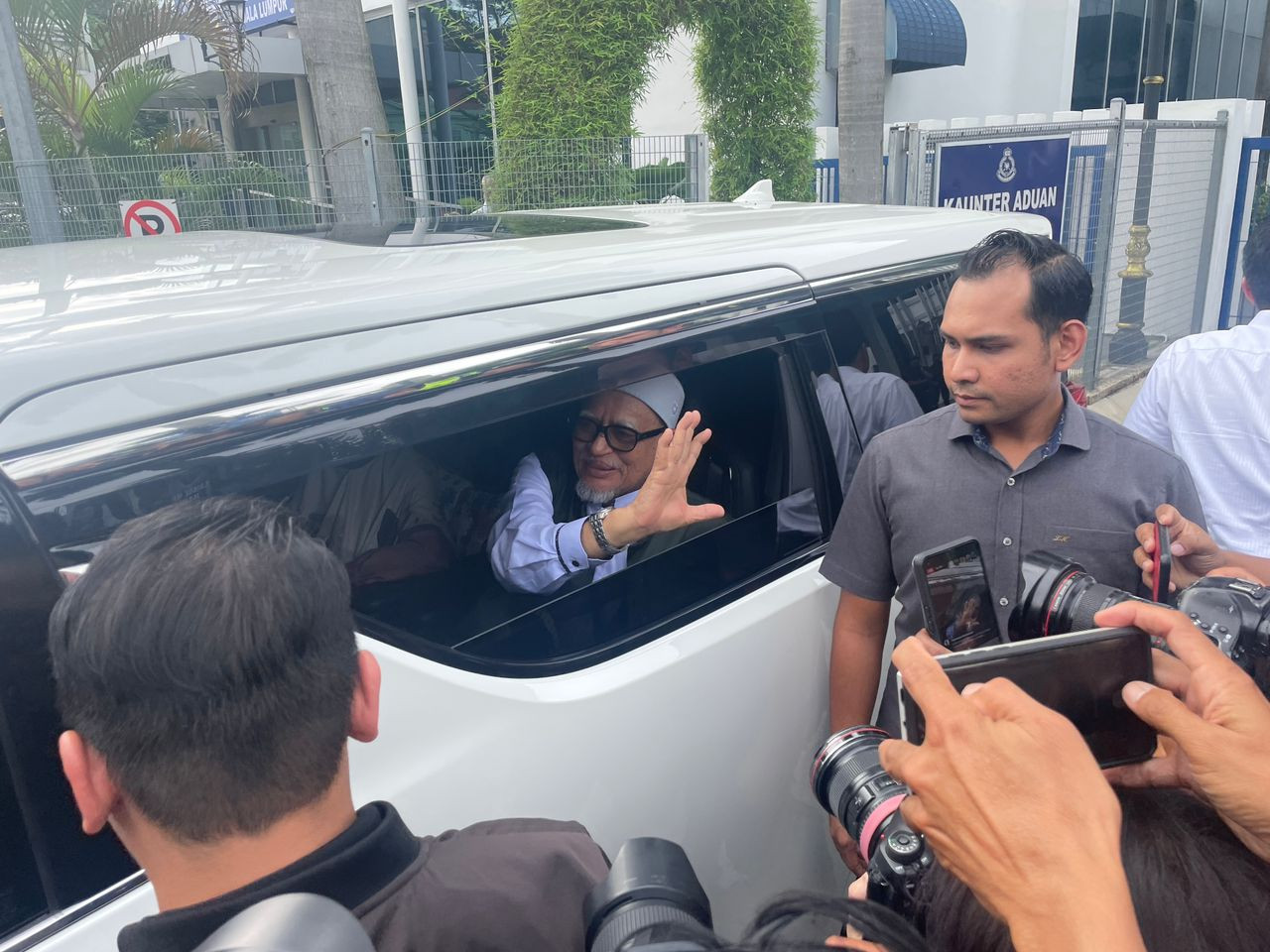 Abdul Hadi melambaikan tangan kepada petugas media sebelum beredar dari IPD Sentul. - Gambar oleh Fitri Nizam