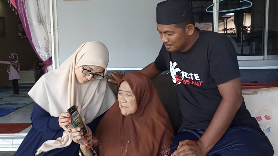 Painam (tengah) serta Mohd Hairudin (kanan) melihat foto Iqbal dan keluarganya ketika ditemui Getaran hari ini.