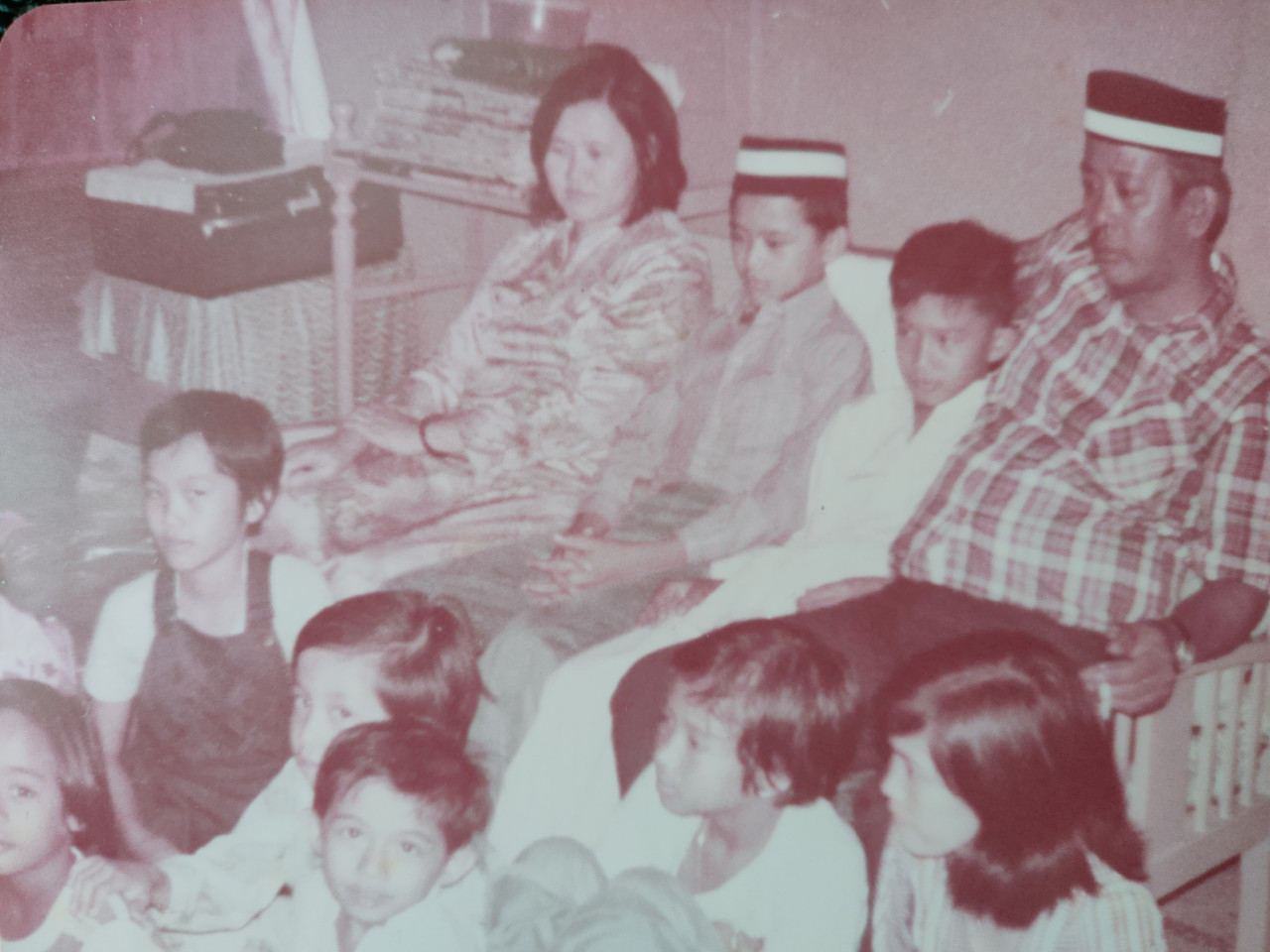 Sesi menonton TV di ruang tamu yang padat ketika Hari Raya.