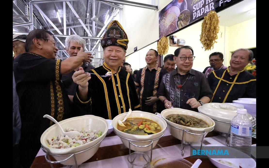 Tan Sri Joseph Pairin Kitingan (tiga, kiri) menunjukkan makanan tradisional ‘Hinava’ selepas merasmikan pembukaan Hongkod Avenue di Hongkod Koisaan Penampang, semalam. - gambar BERNAMA