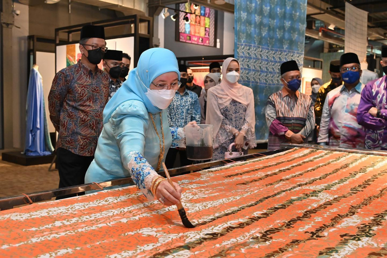 Raja Permaisuri Agong memberi demonstrasi melukis batik. - Gambar daripada Facebook Istana Negara